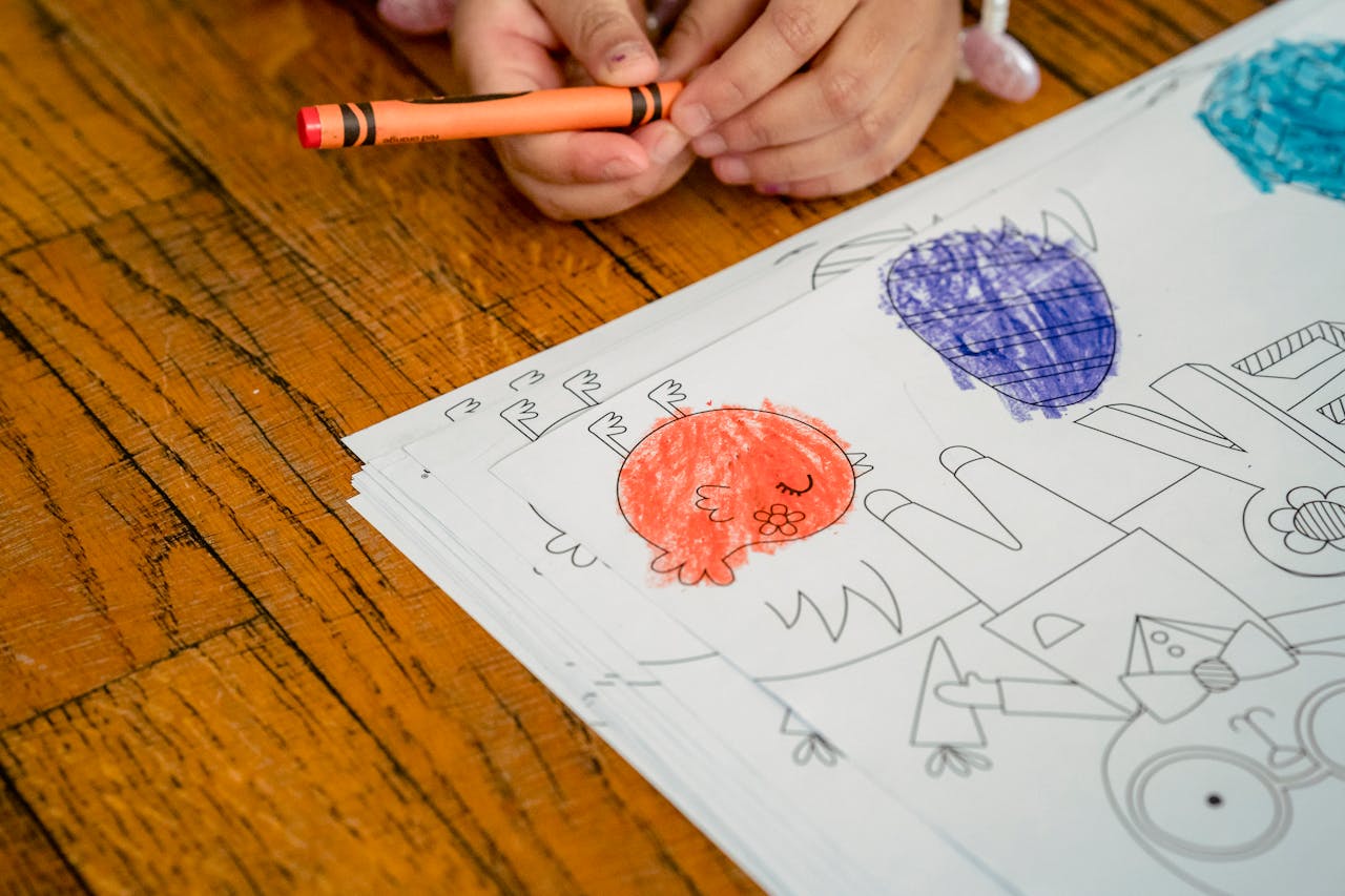 A child colors Easter themed designs on paper with crayons, capturing creativity and holiday fun.